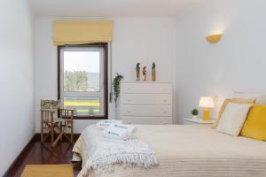 una camera da letto con un letto con due asciugamani sopra di Host Wise - Spacious Modern Beach House - Esposende a Marinhas