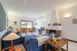 un soggiorno con un divano blu e un camino di Host Wise - Spacious Modern Beach House - Esposende a Marinhas