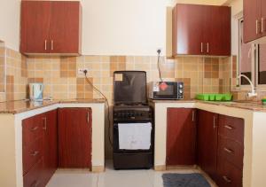 a kitchen with a stove and a microwave in it at A Cozy 3 Bed Apartment With a Swimming Pool in Nyali - Beach Front in Mombasa