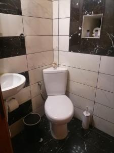 a bathroom with a white toilet and a sink at To Kyma in Skala Kallirakhis