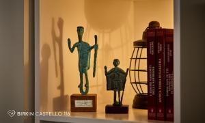 a shelf with a statue and books on it at Albergo Diffuso Birkin Castello in Cagliari