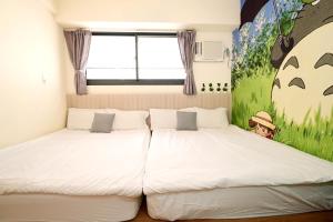 a bedroom with two beds and a painting on the wall at Taichung FJ Victoria in Taichung