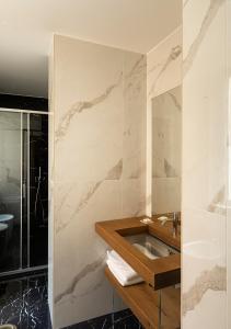 uma casa de banho com um lavatório e uma parede em mármore em Hotel Regno em Roma