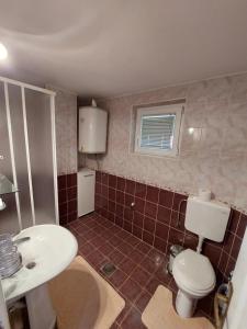 a bathroom with a white toilet and a sink at Vila Pavle in Užice