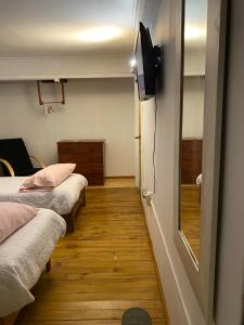 a room with two beds and a television on the wall at El Pillan "Travelers" House in Santiago