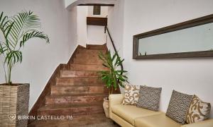 a living room with a couch and a staircase at Albergo Diffuso Birkin Castello in Cagliari