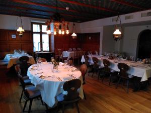 Hotel Sonne Sissach في سيساتش: غرفة مع طاولات وكراسي مع مفارش بيضاء