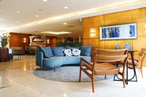 a living room with a blue couch and a table at Hotel Premium Campinas in Campinas