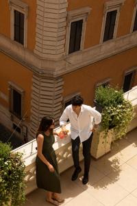 Un uomo e una donna in piedi davanti a un palazzo di Hotel Regno a Roma