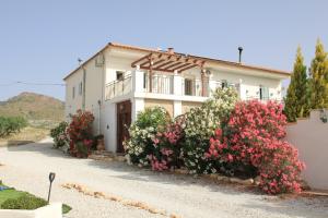 a white house with flowers in front of it at Casa Nuestro Sueño in Oria