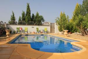 a swimming pool in a yard with chairs and trees at Casa Nuestro Sueño in Oria