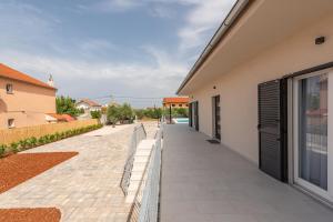 a walkway next to a building with a fence at Villa Golubica in Sukošan