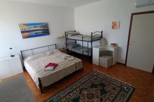 - une chambre avec 2 lits superposés et un tapis dans l'établissement Appartamento Solaris con piscina a Fano, à Fano