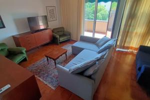 - un salon avec un canapé et une télévision dans l'établissement Appartamento Solaris con piscina a Fano, à Fano