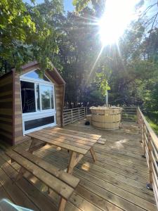 a wooden deck with a picnic table on a cabin at Tiny house du Château du Boulay-Morin in Le Boulay-Morin