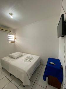 a small bedroom with a bed and a blue stool at Pousada o Paraiso in Camamu