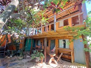 uma casa de madeira com uma mesa e cadeiras em frente em Pousada Flor de Maio - Vila De São Jorge em Alto Paraíso de Goiás