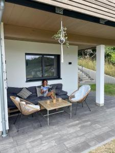 a woman sitting on a couch on a patio at Ferienwohnung Biedenkopf in Biedenkopf