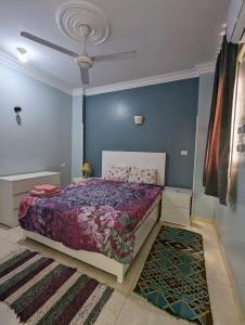 1 dormitorio con cama y pared azul en Villa Rebecca en Luxor