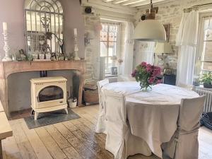 sala de estar con mesa y chimenea en Maison du bonheur en Pouilly-en-Auxois