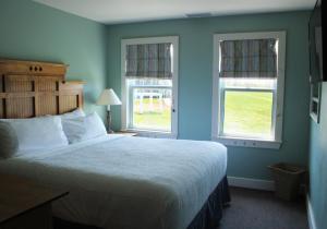 1 dormitorio con 1 cama grande y 2 ventanas en Rodd Crowbush Golf & Beach Resort, en Morell