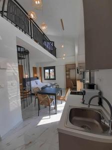 a kitchen with a sink and a living room with a bed at ACTA Luxury Rooms in Nikiti