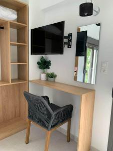 een kamer met een bureau met een stoel en een spiegel bij ACTA Luxury Rooms in Nikiti