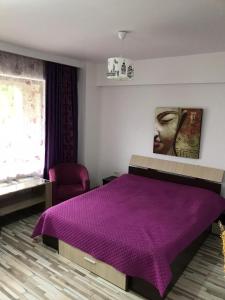 ママイアにあるBlack Sea Apartamentのベッドルーム1室(紫の毛布が敷かれたベッド1台付)
