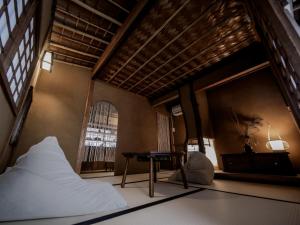 淡路的住宿－古民家ゲストハウス CHACHACHA AWAJI，一间卧室配有一张床、一张桌子和一个窗户。