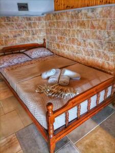 a wooden bed with two towels on it at To Kyma in Skala Kallirakhis