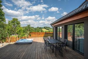 a patio with a table and chairs on a deck at Farma František in Stachy