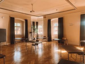 a room with tables and chairs and windows at JUFA Hotel Stift Gurk in Gurk