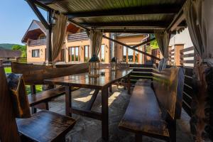 a wooden table and chairs on a patio at Vila Veve in Sighişoara