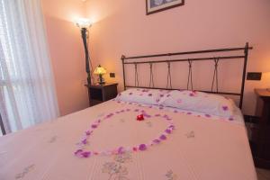 een bed met een hart gemaakt van bloemen erop bij Il Falco del Cilento in Torchiara