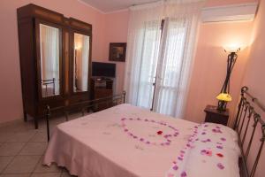 a bedroom with a bed with a flower necklace on it at Il Falco del Cilento in Torchiara