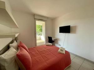 een slaapkamer met een rood bed en een televisie aan de muur bij Panier de Papet, Vélodrome/Prado avec Terrasse 3 in Marseille