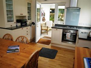 a kitchen with a table and a stove top oven at Seabank Cottage in Rockcliffe