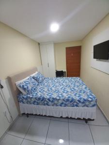 Schlafzimmer mit einem Bett und einem Flachbild-TV in der Unterkunft Hotel Kairos in Campina Grande