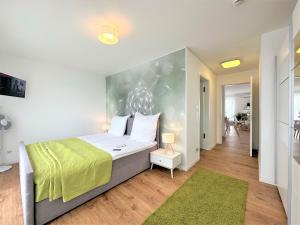 een slaapkamer met een groot bed en een groene deken bij Panorama Penthouse Apartment mit Klima und Whirlpool für bis zu 6 Personen in Frankenthal