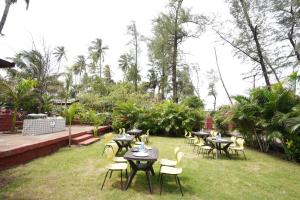 a group of tables and chairs in a garden at Tranquil Beach Resort in Harihareshwar