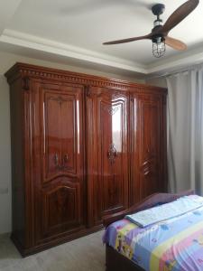a large wooden cabinet in a bedroom with a bed at Premium Sea View Chalet in Azha Ain Sokhna in Ain Sokhna