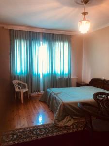 um quarto com uma cama e uma janela com cortinas azuis em Exotic em Nabran