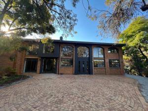 a large brick building with a large driveway at Afrique134 Baobab Tree Private Family Garden Suite in Pretoria