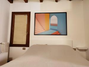 Schlafzimmer mit einem Bett und einem Fenster in der Unterkunft La Dimora di William Casa nel centro storico di Desenzano in Desenzano del Garda