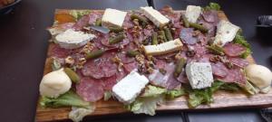 un'insalata con carne e formaggio su un tagliere di Chambre indépendante piscine en saison petit déjeuner inclus a Véretz Altre 3 foto