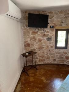 een kamer met een televisie aan een stenen muur bij La traversa in Sannicola