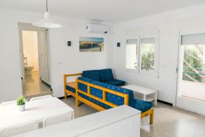 sala de estar con 2 sillas azules y mesa en Apartaments Falcó, en Llançà