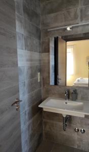 een badkamer met een wastafel en een spiegel bij Villa Grácia in Badacsonytomaj