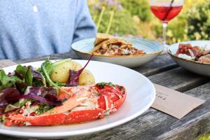 a table with two plates of food and a glass of wine at Housel Bay Hotel in Lizard
