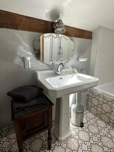 博恩地區聖朱利安的住宿－La Ferme du Miouat，浴室配有盥洗盆、镜子和浴缸